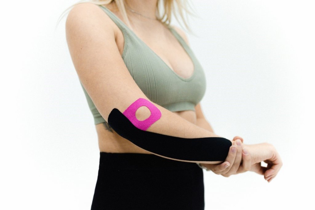 woman wearing sports tape on her elbow and forearm