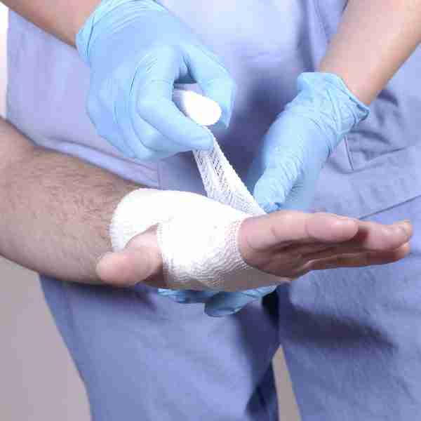 Close up image of hand being wrapped in a cohesive bandage.